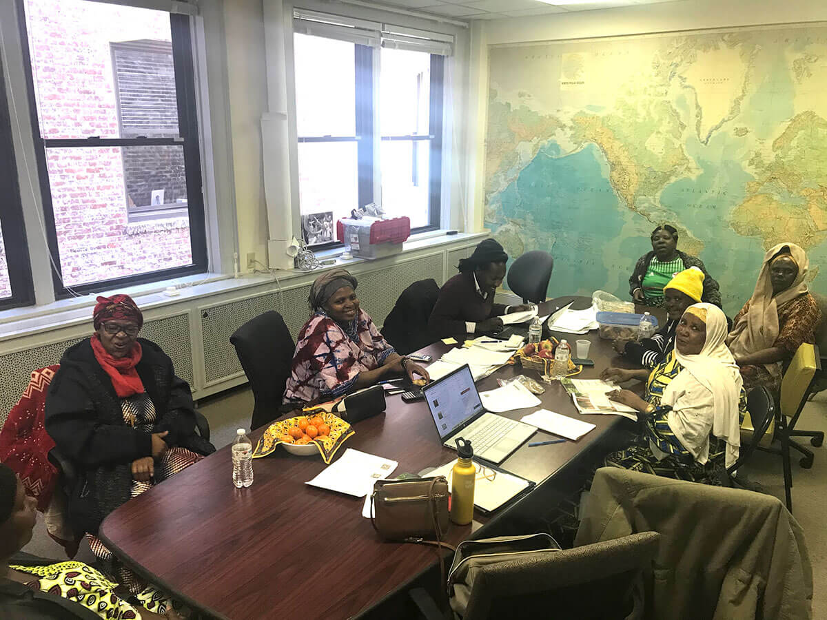 Room of mixed cultured women sitting at a table for a meeting